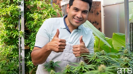 man in a greenhouse with thumbs up