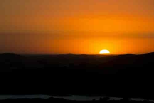 Sun rising over mountain hill