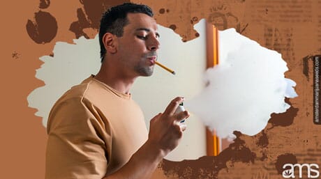 a man smokes and sprays natural deodorant with a spray in his house